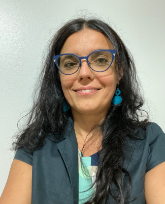 Medium close-up of a woman wearing glasses indoors.