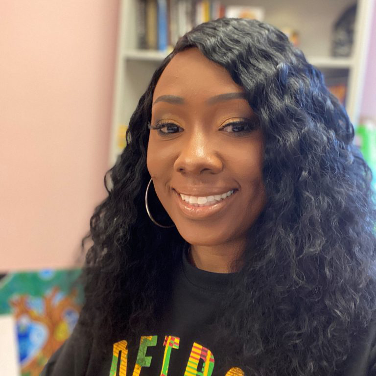 A picture of a woman with long black hair smiling at the camera.