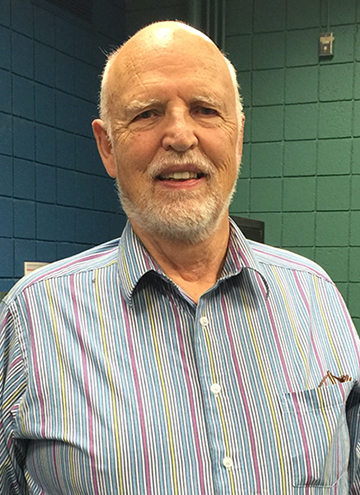 Photo of William Vincent. Older man with white beard, wearing colorful striped shirt.