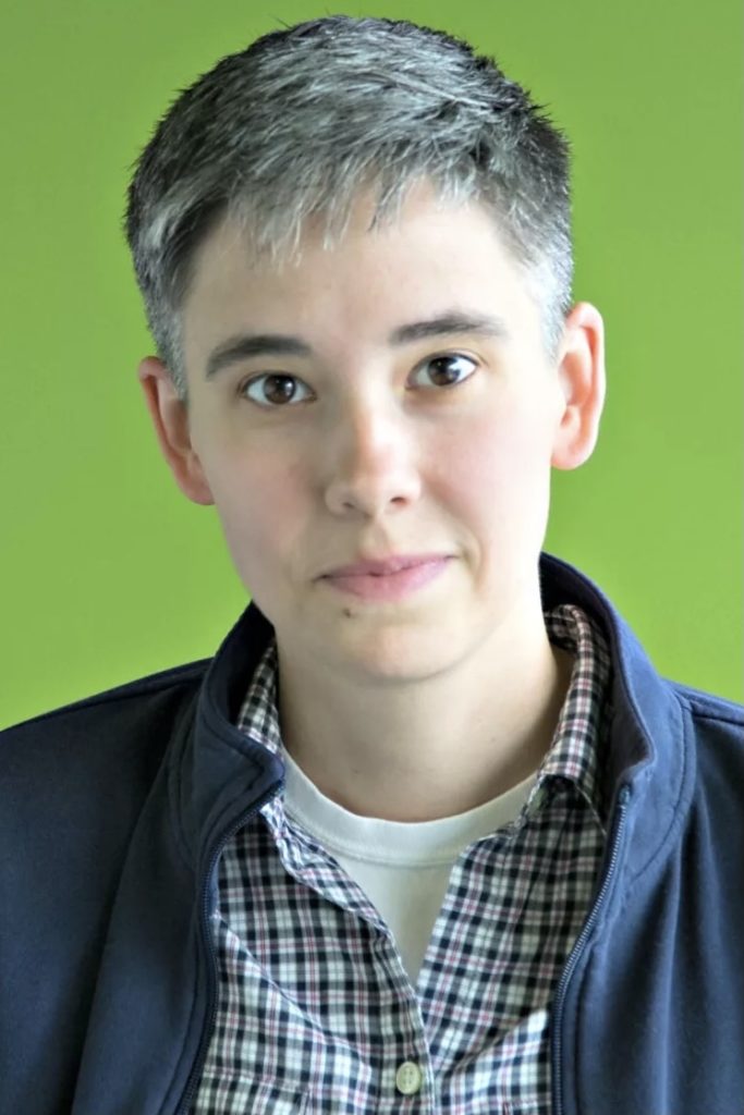 Portrait of person in front of green background.